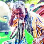 An elderly rickshawpuller pouring water on his face to get some relief from the scorching heat that prevails across the country for several days.