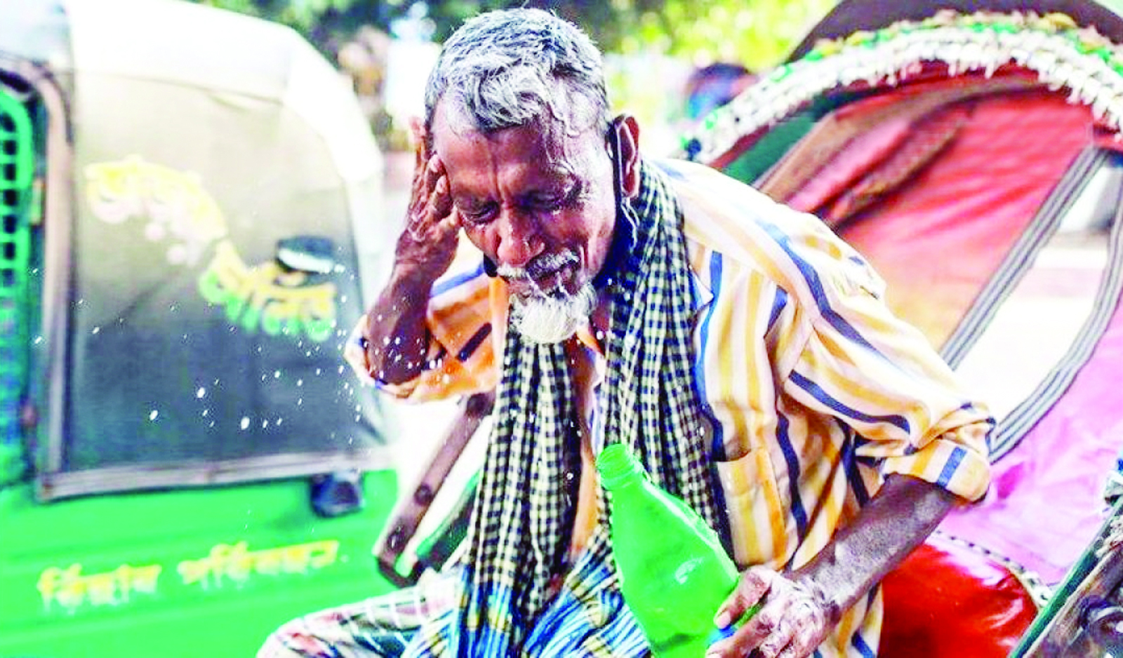 An elderly rickshawpuller pouring water on his face to get some relief from the scorching heat that prevails across the country for several days.