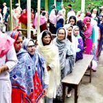 Women wait to cast their votes at a polling station during the first phase of the general election, in Imphal, Manipur, India, April 19, 2024.