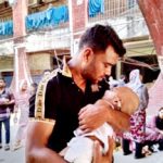 The image shows a man holding a baby after the fire broke out at the Bangladesh Shishu Hospital in Dhaka on Friday, April 19, 2024.