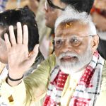 Narendra Modi waves to supporters during an election campaign rally in Kolkata.