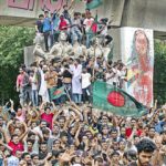 Protesters climb a public monument as they celebrate after getting the news of Prime Minister Sheikh Hasina’s resignation in Dhaka on Monday.