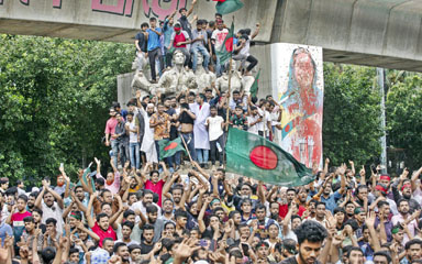 Protesters climb a public monument as they celebrate after getting the news of Prime Minister Sheikh Hasina’s resignation in Dhaka on Monday.